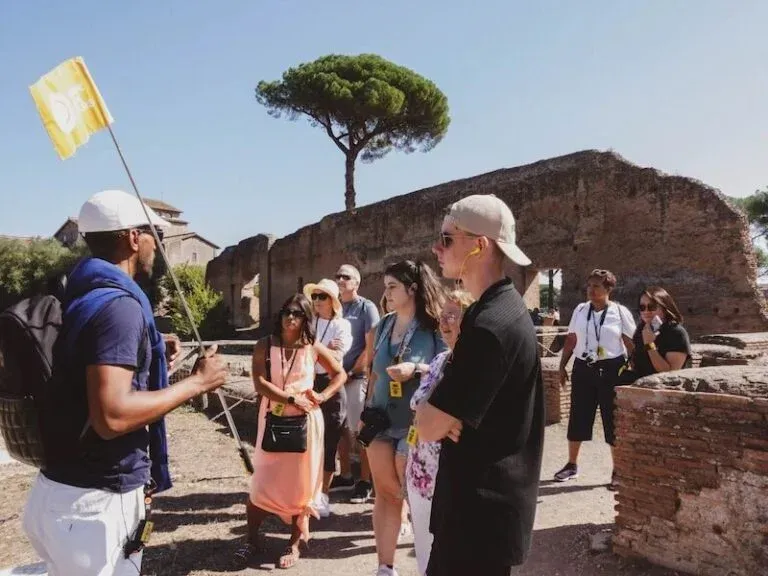 Group of tourists with professional guide exploring ancient Roman archaeological site and historical ruins during Carpe Diem Tours Rome educational experience