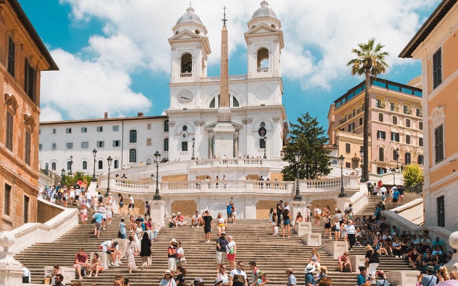 View of the Spanish Steps in Rome, Italy, looking up towards the Trinità dei Monti church, crowded with people