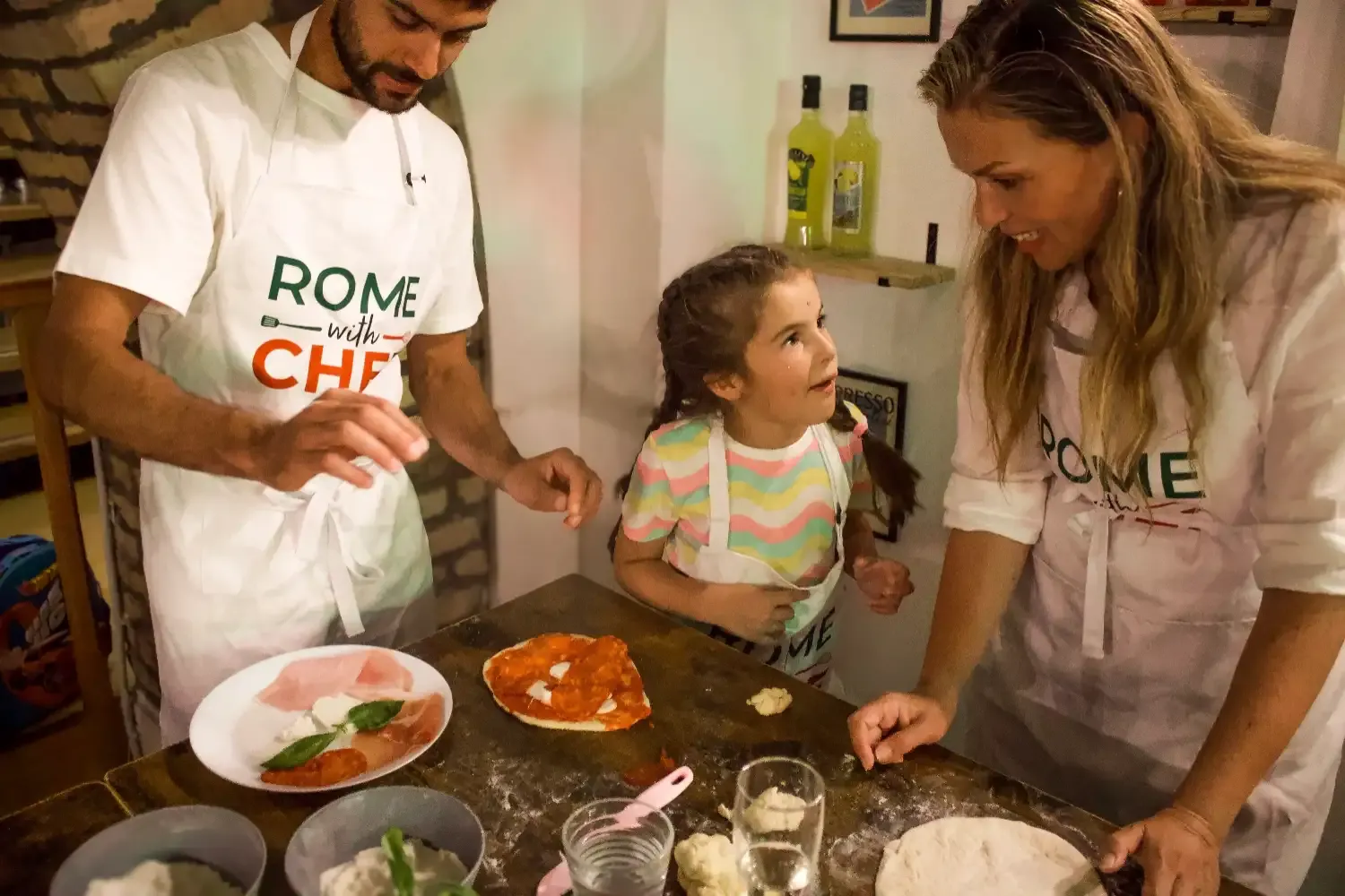 Family with young child enjoying fresh Margherita pizza with mozzarella and basil during the cooking class