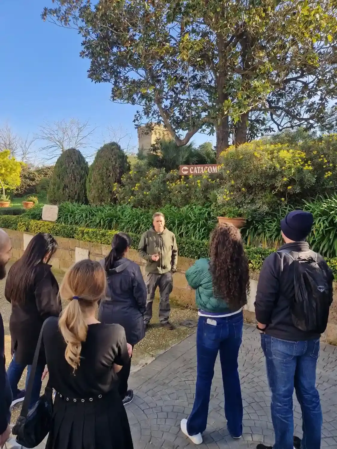 Tourists exploring narrow corridors in Rome's underground catacombs