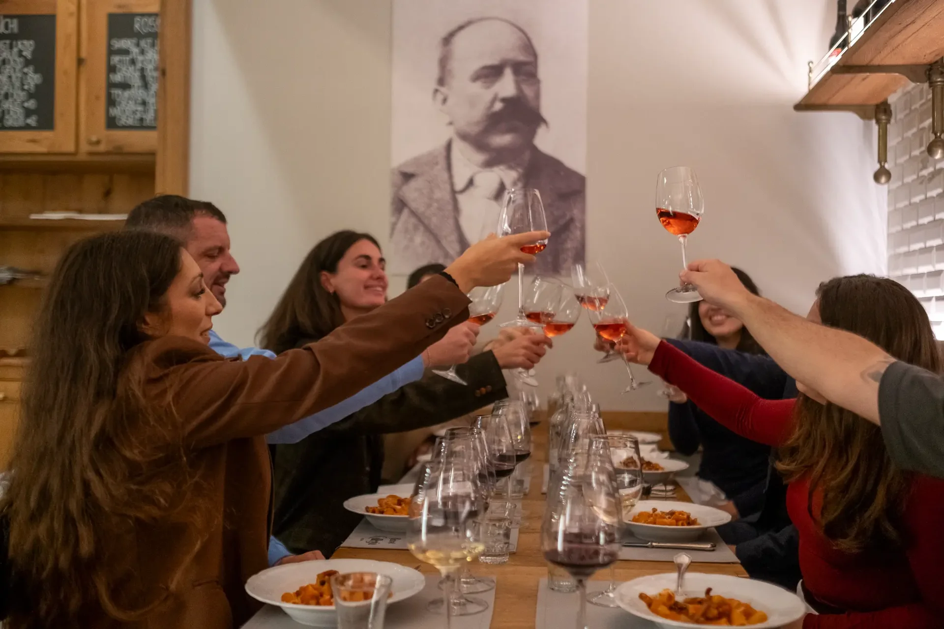 Friends raising their glasses for a wine toast during a celebration dinner at a fine dining establishment.